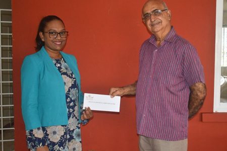 Manager of Regal Stationery and Computer Centre Telesha Ousman (left) hands over the donation to Rajnarine Singh of the Guyana Hindu Dharmic Sabha.