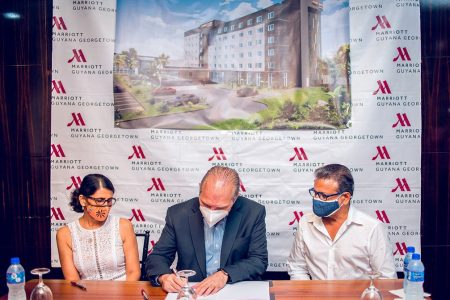 Signing of the Agreement. From left are Denise Bassoo, Eduardo Reple and Roy Bassoo