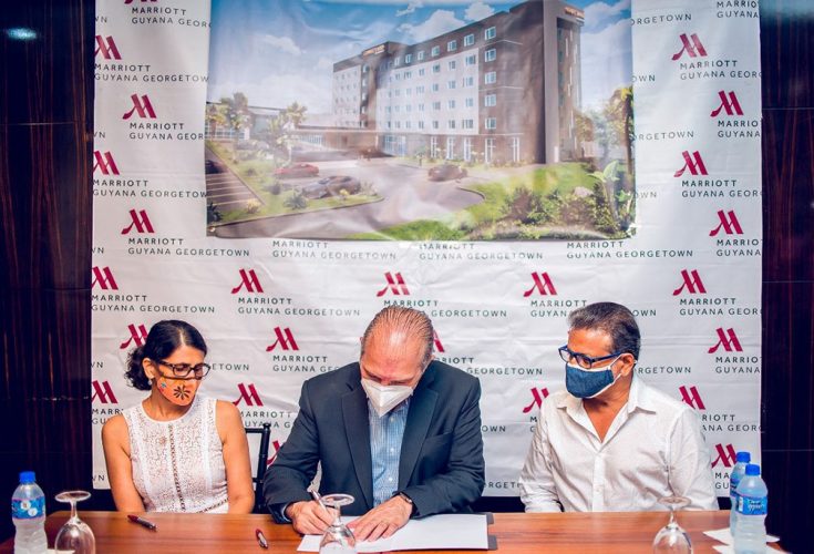 Signing of the Agreement. From left are Denise Bassoo, Eduardo Reple and Roy Bassoo