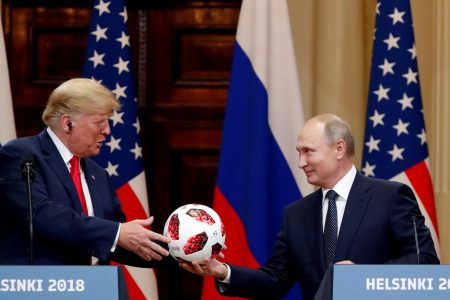 U.S. President Donald Trump receives a football from Russian President Vladimir Putin as they hold a joint news conference after their meeting in Helsinki, Finland July 16, 2018. REUTERS/Grigory Dukor/File Photo