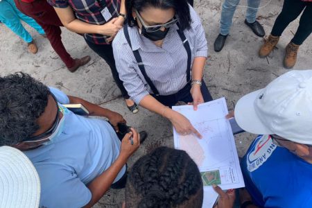 Junior Housing Minister Susan Rodrigues and officials from Guyana Lands and Surveys Commission and the Central Housing and Planning Authority review a map of an area occupied by informal settlers at Amelia’s Ward, in Linden. During a visit on Friday, Rodrigues urged residents against unlawfully occupying land while announcing that her ministry is forging ahead with a plan to develop 2000, house lots in the community.