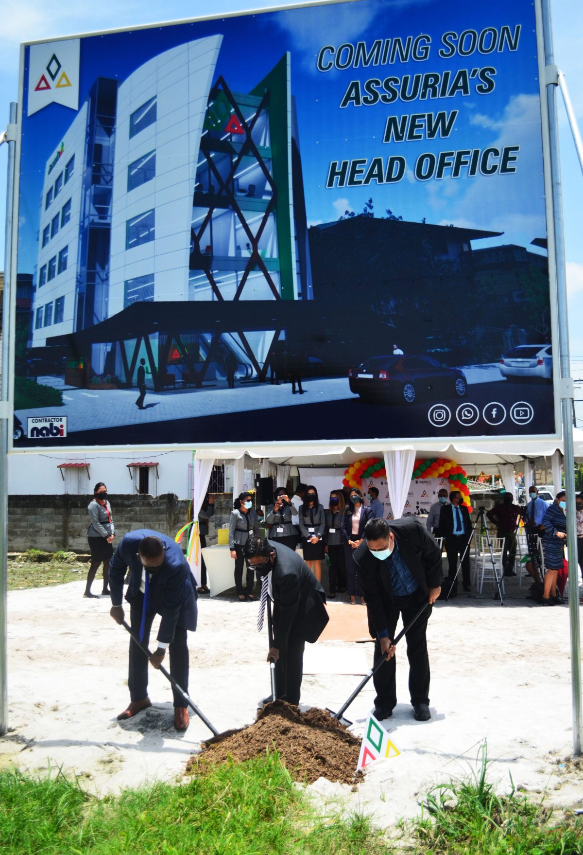 Yogindra Arjune (right) and Dr Ashni Singh (centre) turn the sod for the construction of the new head office. The artist’s impression is displayed on the billboard above them (Orlando Charles photo)