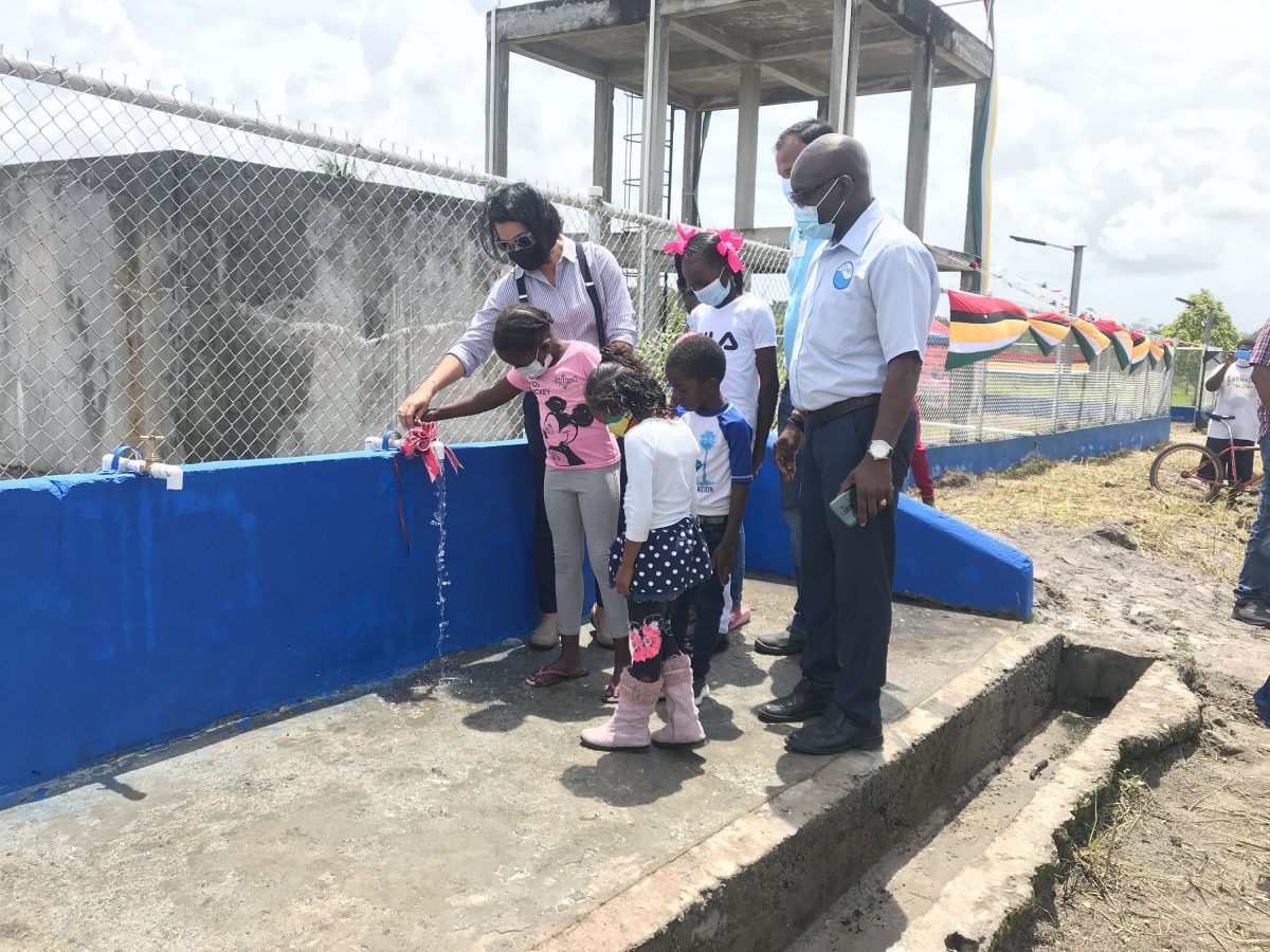 GWI recommissions Moblissa well: Minister Susan Rodrigues and children of Moblissa ceremonially turn on a standpipe at the well for the recommissioning of the community’s water supply system. 