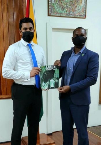 GFF President Wayne Forde (right) presenting a copy of the entity’s 2020 Annual Report to Minister of Culture, Youth and Sport Charles Ramson Jr.,