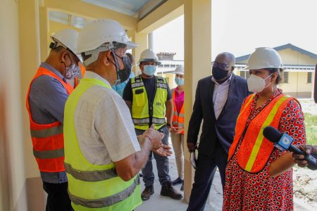 Minister Priya Manickchand (right) engaging BK  Tiwarie and Ganesh Sawh during the visit to the school. (Ministry of Education photo) 