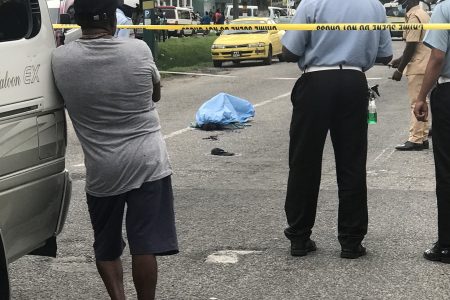 The body of the deceased man surrounded by police at the scene