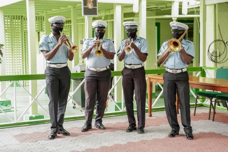 Members of the Guyana Police Force playing their brass instruments through their masks. They were serenading President Irfaan Ali yesterday at State House on the occasion of his birthday. (Office of the President photo)