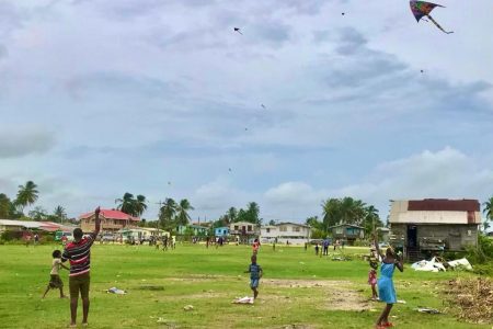 Easter scene: These Vryheid’s Lust, East Coast Demerara families flew their kites in wide open spaces yesterday. Public kite-flying venues along the seawall and other areas were closed to the public yesterday because of COVID-19 restrictions. (Photo by David Papannah)