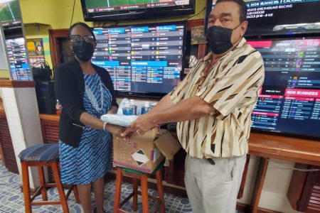 Raymond Ali hands over the masks and sanitizers to secretary of the GDA, Ann Thompson.