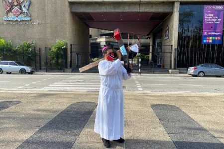 Archbishop Fr Jason Gordon re-enacts one of the 14 Stations of the Cross in front the Twin Towers in Port of Spain yesterday. —Photo: MICHELLE LOUBON