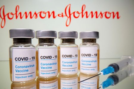 FILE PHOTO: Vials with a sticker reading, "COVID-19 / Coronavirus vaccine / Injection only" and a medical syringe are seen in front of a displayed Johnson & Johnson logo in this illustration taken October 31, 2020. REUTERS/Dado Ruvic/Illustration/File Photo