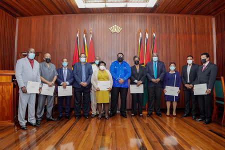 President Irfaan Ali (centre), Prime Minister Mark Phillips (fourth, from right) Minister of Local Government and Regional Development Nigel Dharamlall (second, from right) and Minister within the Ministry of Local Government and Regional Development Anand Persaud (fourth, from left) with the members of the newly sworn in Local Government Commission. 