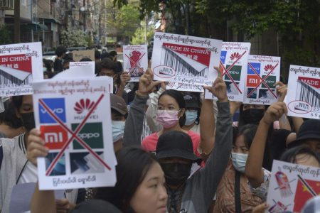 Anti-coup protesters hold slogans calling for a boycott of Chinese products during a demonstration in Yangon on April 7, 2021. The Associated Press