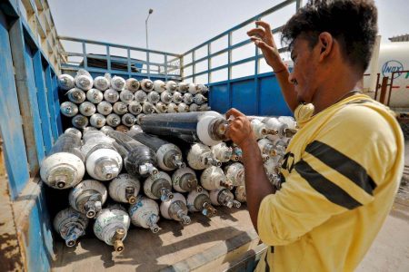 A worker loads empty oxygen cylinders onto a supply van to be transported to a filling station, at a Covid-19 hospital, amidst the spread of the coronavirus disease (Covid-19) in Ahmedabad, India, April 22, 2021. — Reuters pic