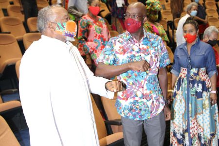 Prime Minister Dr Keith Rowley is given an elbow bounce by an unidentified man on his arrival to the PNM’s Spiritual Shouter Baptist Liberation Day celebration at the Government Campus Plaza Auditorium in Port-of-Spain, on March 27.