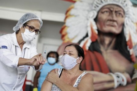 A healthcare worker shows the syringe to a woman after applying a dose of Sinovac's CoronaVac coronavirus disease (COVID-19) vaccine at Cacique de Ramos, one of the most traditional carnival blocks of Rio de Janeiro, Brazil April 8, 2021. REUTERS/Ricardo Moraes