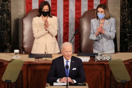 President Joe Biden (foreground) speaking last night. Vice President Kamala Harris is at left. Also in photo is House Speaker Nancy Pelosi. (Reuters photo)