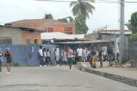 Party-goers at a private event at Production Drive, Sea Lots, stand along the roadway after they were warned by officers from the Port-of-Spain Division Task Force to disperse yesterday.