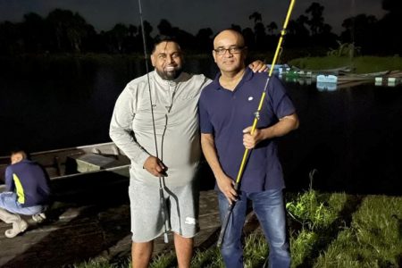 Midnight fishing curfew breach: President Irfaan Ali (left) and Vice President Bharrat Jagdeo during a fishing trip at the Boerasirie Conservancy, Region Three on Saturday night.
The photo was posted on Ali’s Facebook page with the caption `Midnight fishing in the Boerasirie Conservancy, Region Three last night’ on Sunday morning.
It was widely circulated with concerns being raised about them breaching the COVID-19 curfew of 10.30 pm to 4 am and not adhering to the guidelines of social distancing and wearing face masks.
Dozens of Guyanese in all parts of the country have been charged with breaching the curfew and other COVID-19 regulations. Serious concerns have also been expressed by government officials including the President that COVID-19 regulations were not being taken seriously. On March 7th this year, the President left a cricket event at the Everest Ground after expressing concern that persons were not wearing face masks.
No guidelines have yet been instituted here allowing fully vaccinated persons to do away with masks. Observers have also pointed out that the President and Vice President would have been accompanied by their security retinues during the fishing trip.  (Photo taken from President Irfaan Ali’s Facebook page)