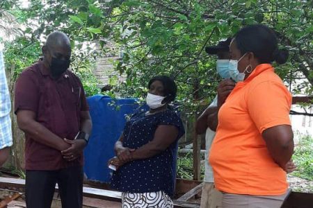 Minister of Home Affairs Robeson Benn speaking with murdered bartender Shonnette Dover’s relatives yesterday 