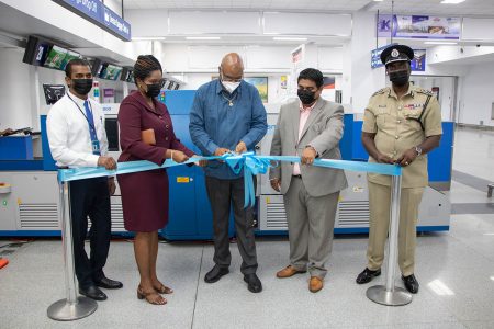 Minister Juan Edghill cutting the ribbon for the newly-installed screening equipment