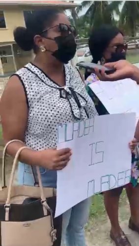 Peter Headley’s wife, Patricia Campbell carrying a placard which read `Murder is murder’ during the protest yesterday. 