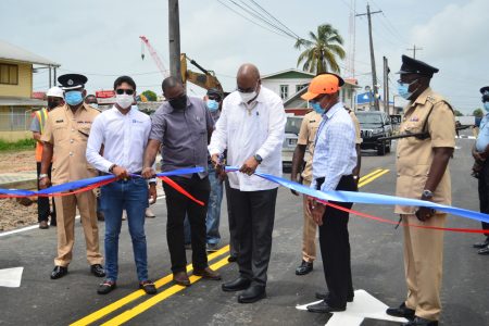 Minister of Public Works Juan Edghill cutting the ribbon yesterday at the re-opening of the Hunter Street roadway