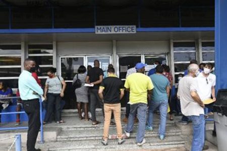 People line up at the Licensing Office on Wrightson Road, Port of Spain, yesterday, amid new Covid-19 restrictions.