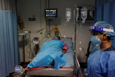 A man suffering from coronavirus disease (COVID-19) receives treatment as a Syringe Infusion Pump, donated by France is seen next to his bed, inside the emergency room of Safdarjung Hospital in New Delhi, India, May 7, 2021. REUTERS/Adnan Abidi