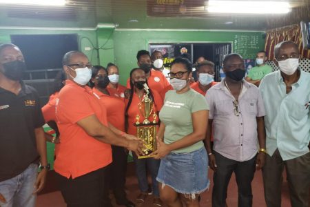 Winners: Lovern Spencer hands over the winning trophy to Captain Claire Benjamin of Cody’s Girls who are the inaugural `Three the Hard Way’ salute mothers champions with team manager Neville `Cody’ Cadogan.