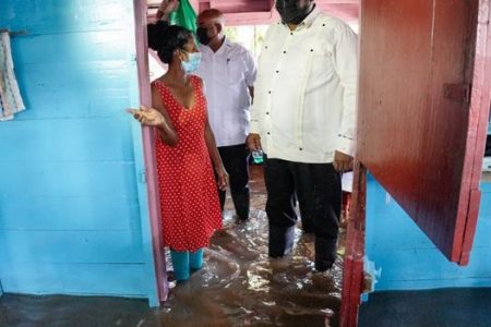 President Irfaan Ali (right) inspecting the flooded home of a resident of Mahaicony Creek (Office of the President photo)
