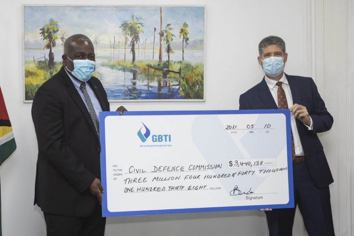  GBTI’s CEO (ag), James Foster (right) handing over the cheque to Prime Minister Mark Phillips. (GBTI photo)