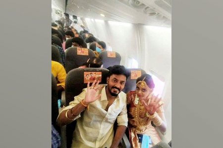 Bride Dakshina and groom Rakesh pose as they perform a wedding ritual during a flight, amid the pandemic, in this still image taken from a video dated on May 23, 2021 Reuters