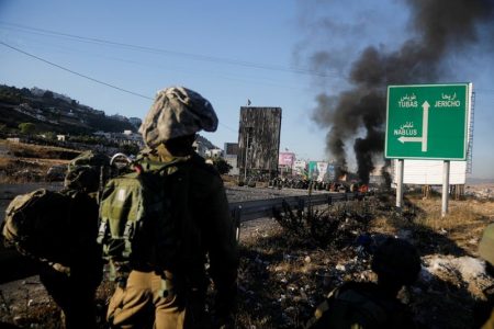 Israel's soldiers look on during an anti-Israel protest over cross-border violence between Palestinian militants in Gaza and the Israeli military, near Hawara checkpoint near Nablus in the Israeli-occupied West Bank, May 18, 2021. REUTERS/Raneen Sawafta
