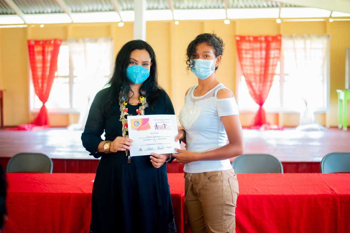 Minister Vindhya Persaud (left) handing out a certificate
