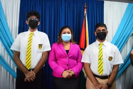 The top CAPE performer Zane Ramoutar (left) and the top CSEC performer, Bhedesh Persaud (right) posing with Minister of Education Priya Manickchand. 