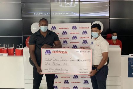 Marics and Company Ltd Inventory Controller Khemraj Jaikaran (at right) hands over the $1 million cheque to Deputy Director of the Civil Defence Commission Major Loring Benons at the company’s showroom on Friday