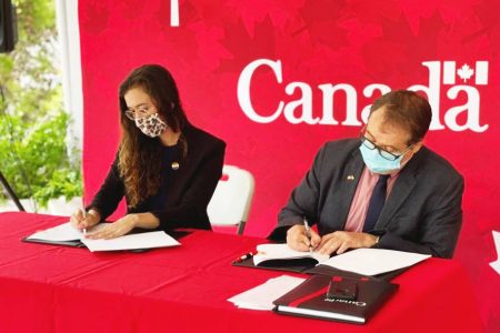 Canada’s High Commissioner Mark Berman (right) and Country Manager for HIAS Guyana, Alex Theran signing the document. (Canadian High Commission photo)