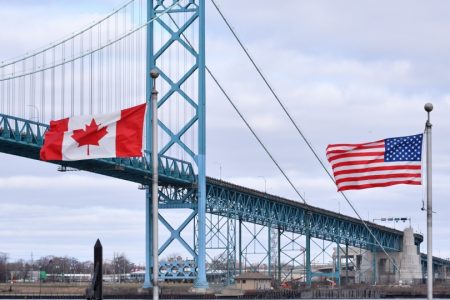 Canadian and American flags fly near the Ambassador Bridge at the Canada-USA border crossing in Windsor, Ont. on Saturday, March 21, 2020. THE CANADIAN PRESS/Rob Gurdebeke