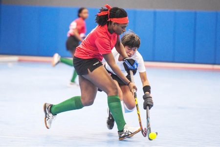 Guyana’s Makeda Harding (left) trying to keep possession against Canada’s Alison Lee during their clash in the 2021 Indoor Pan Am Cup (IPAC) yesterday in the USA.