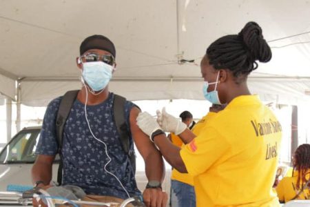 This cyclist took advantage of the Ministry of Health’s COVID-19 vaccination drive at MovieTowne yesterday. The event catered for persons getting vaccinated from the comfort of their vehicles. (Department of Public Information photo) 