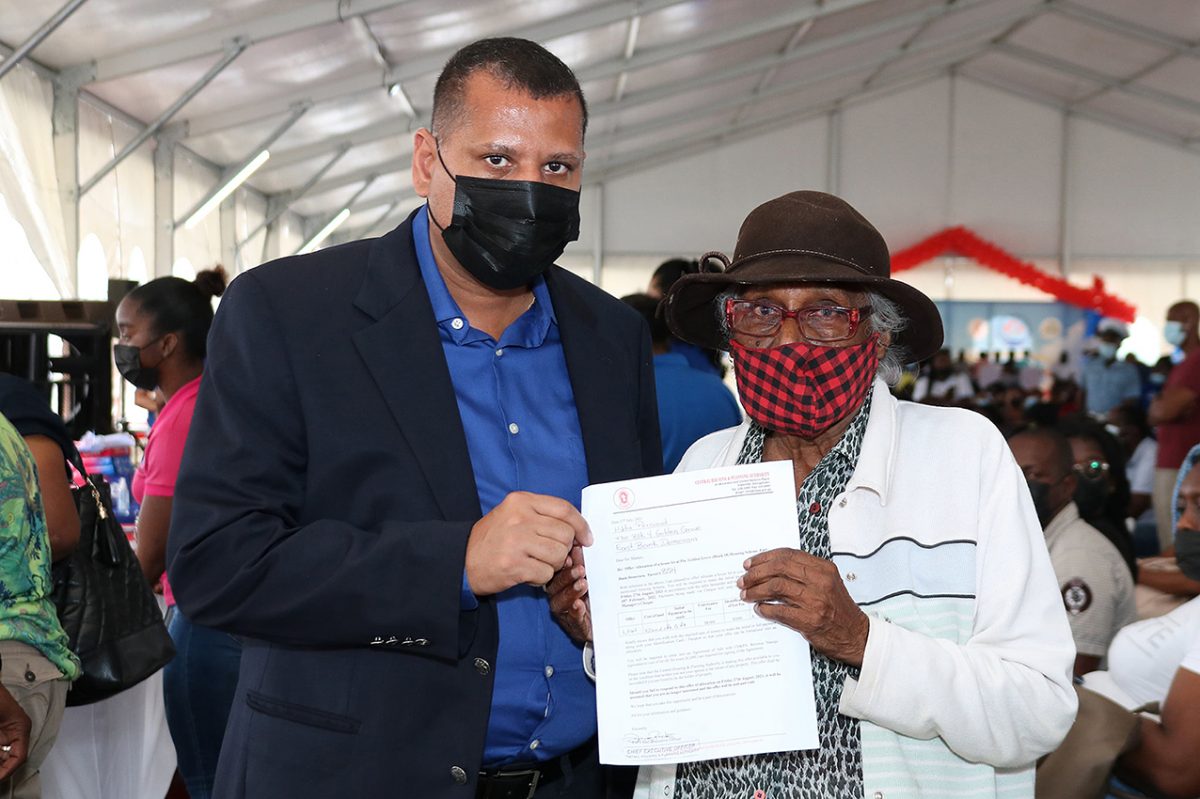 Minister Collin Croal (left) and Hilda Persaud, the 90-year-old house lot awardee (Ministry of Housing and Water photo)
