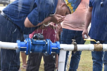 Minister of Housing and Water Collin Croal drinking water from the upgraded St. Ignatius water supply system.  (Central Housing and Planning Authority photo)