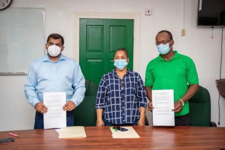 From left are GTT Financial Adviser Mark Singh, acting Chief Labour Officer Michelle Baburam and GPTWU President Harold Shepherd with their copies of the agreement (DPI photo)