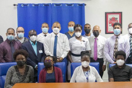 Dr. Germaine Bristol (seated second from right) and her son Gerome Bristol (seated at right) along with Dr. Nyamekeye Griffith (seated second from left) flanked by Minister of Health Dr. Frank Anthony (standing near centre with tie), the ministerial advisor and team from the transplant department. (Ministry of Health photo)