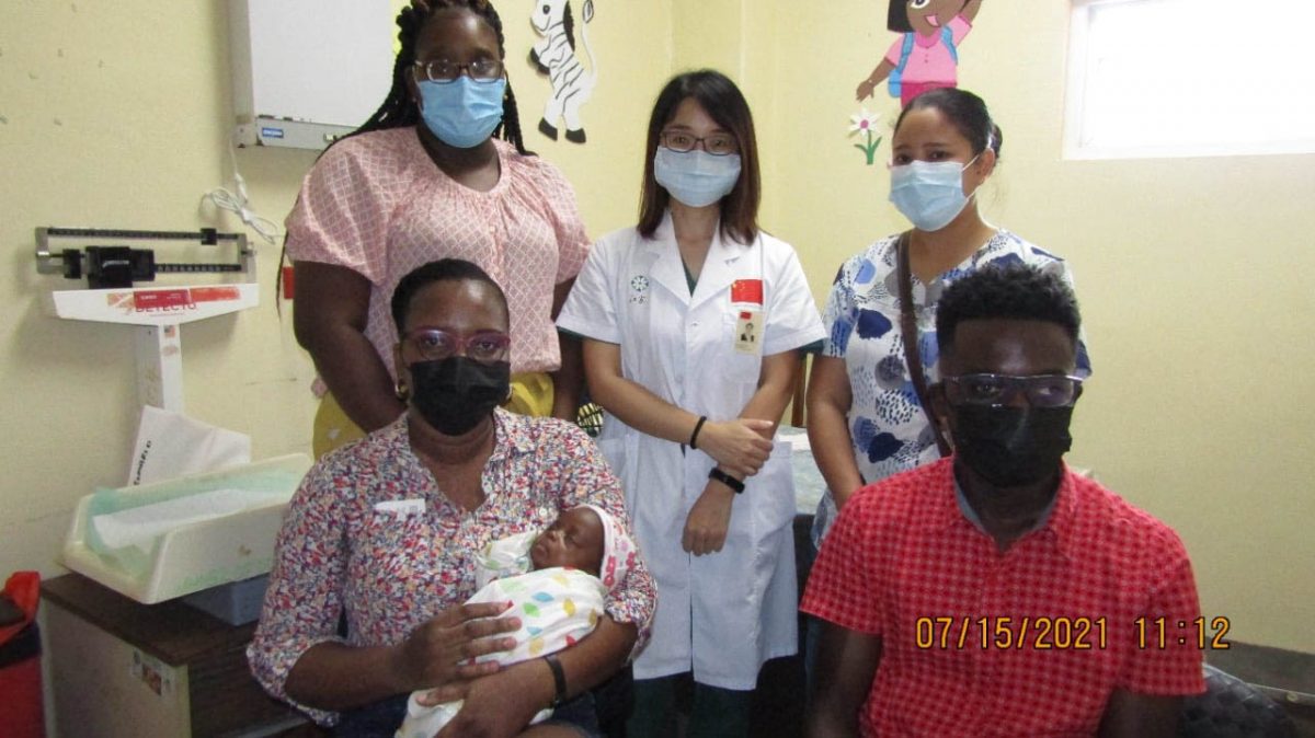 Fiona Jones (seated with baby) and her husband Simon Jones (seated at right) along with the Paediatric team (from left), Dr. Teani Small, Dr. Wang Xuli and Dr. Barker. (Linden Hospital Complex photo)
