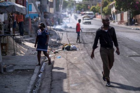 People walk on a street after tires were set on fire by protesters upset with growing violence in the Lalue neighborhood, a week after the assassination of President Jovenel Moise, in Port-au-Prince, Haiti July 14, 2021 Reuters