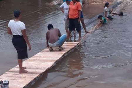 Residents construct a bridge across the section of the road which was washed away when the East Montgomery tailings pond broke 