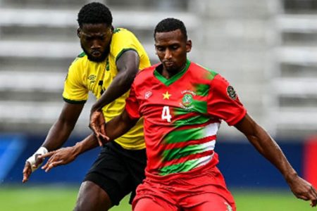 Goal-scorer Shamar Nicholson challenges Suriname’s Dion Malone during Monday’s contest. 