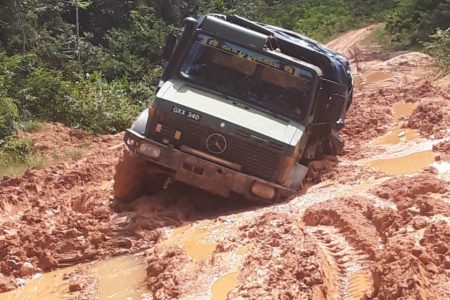 A small truck navigating its way through the deplorable trail 